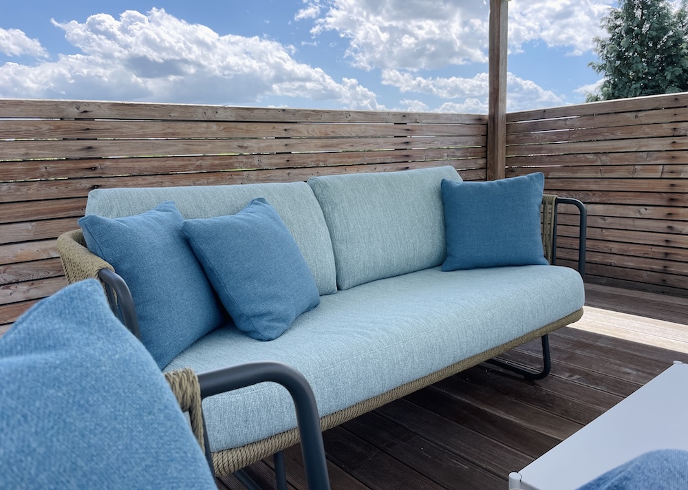 Loungesofa mit dicken Kissen in Blaut&ouml;nen, mit einer Seilflechtung in einem Hanfton. Gartenm&ouml;bel Ausstellung in Ober&ouml;sterreich bei Sabine Unter